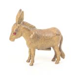 A gilt brass novelty tape measure in the form of a standing mule or donkey, ruby glass eyes,