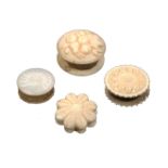 Four circular disc form waxers, comprising an ivory example carved to one side with fruit and
