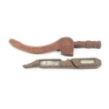 Two 19th Century wooden knitting sheaths comprising a Cumbrian example carved with a fish, a plant
