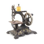 A late 19th Century miniature sewing machine Stitch All, gilt decorated cast iron frame