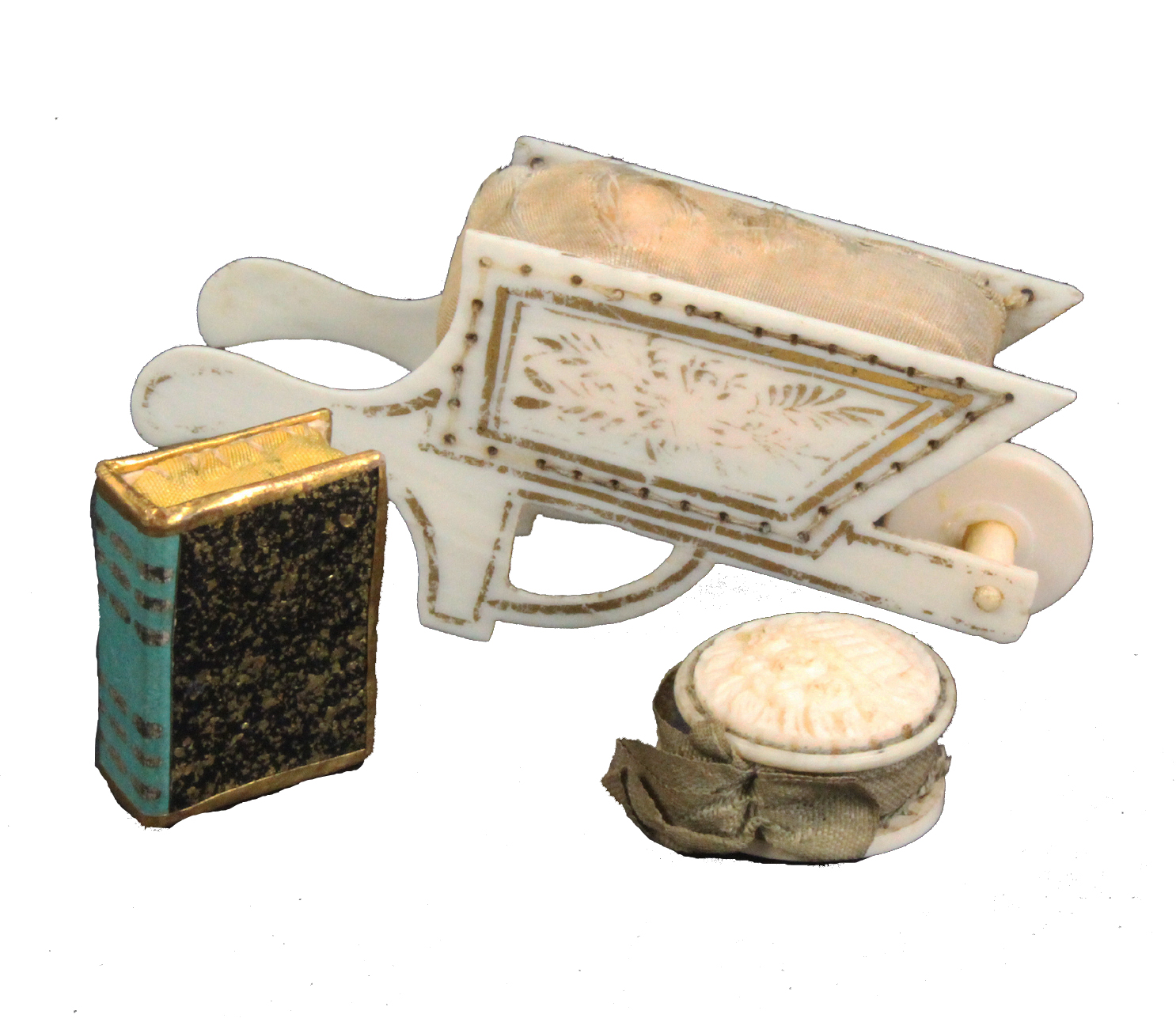 A pincushion and two emeries the ivory pincushion in the form of a wheelbarrow with gilt floral