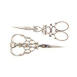 Two fine pairs of steel scissors comprising a pair with oval section tapering blades, the arms in