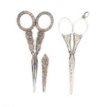 Two pairs of silver handled scissors, one pair with engraved arms to plain loops, one with