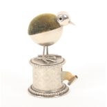 A nickel plated novelty tape measure/ pincushion, the pincushion as a chick on a cylinder form