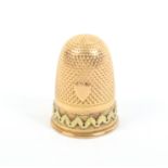 A 19th Century two colour gold thimble, probably French, the body with shield over a zig zag band in