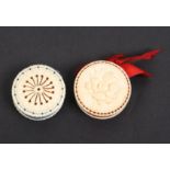 Two 19th Century ivory roundel form pincushions, comprising an example carved in relief to one