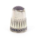 A good silver and enamel Norwegian thimble, amethyst coloured top, over a frieze of cream enamel van