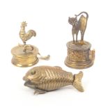 Three novelty brass tape measures comprising a fish, glass eyes, wound by the lower fin 6.5cm,