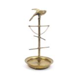 A French brass reel stand in the form of a bird on perch, the bird above six reel rods on a circular