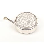 An English silver tape measure of circular form with leaf and scroll decoration, etched steel tape
