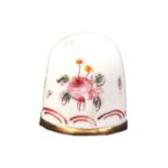 An English Bilston enamel thimble, Ex. Holmes Collection, decorated with flowers over red scrolls