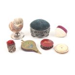 Seven pincushions comprising a natural shell form example on silver base, Birmingham 1909, 5.2cm,
