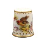 A Royal Worcester thimble painted with a bird on a flowering branch below a gilt band and dots and a