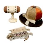 Three pin cushions comprising a bone example in the form of a wheel barrow with cut sides, 5.7cm,