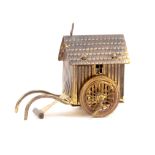 A gilt brass novelty tape measure in the form of a bathing hut, complete printed tape in ins,