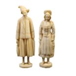 A matched pair of 19th Century carved ivory Dieppe fisherfolk standing needlecases, each in