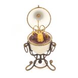 A French gilt metal and opaque glass egg form etui, circa 1870, the egg on scrolling triform stand
