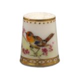 A Worcester porcelain thimble painted with a bird on a flowering branch below a line and gilt dot