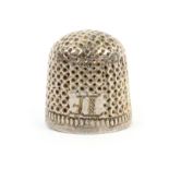 A small English 17th Century silver thimble, of squat form initialled ‘T.F.’ over a plain rim