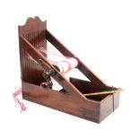 A Georgian mahogany braid loom, rectangular base with triangular side supports to the loom board and