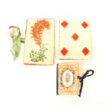 Two needlebooks and a pin card, comprising a floral decorated cardboard needlebook in blue and gilt,