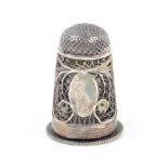 An English silver filigree scent bottle/thimble with vacant oval cartouche within quill work