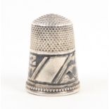 A Russian pre-revolutionary silver and niello work thimble, inscribed and decorated frieze over a