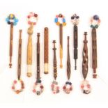 Eleven 19th Century wooden lace bobbins mostly carved, comprising an ebony example with bitted babe,