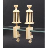 A pair of early 19th Century ivory winding clamps, the rectangular frames below tapering reels and