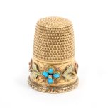 A German gold thimble, the engraved frieze with two turquoise set flower heads linked by varying