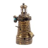 A gilt brass novelty tape measure in the form of a lighthouse, complete printed tape in ins and