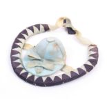 A silk jockey cap pin cushion within a bound ribbon horse shoe with ribbon suspension, 12cm wide