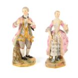 A pair of Meissen figures of a dandy and female companion, late 19th century, he holding a posy in