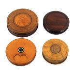 Four 19th Century and later circular wooden snuff boxes comprising a boxwood rotating lid example,