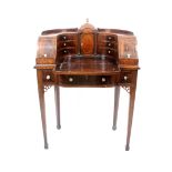 A late 19th century Sheraton style lady’s writing table, the concave superstructure centred by a