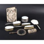 A silver and cream enamel six piece dressing table set, a magnifying glass in white metal mask and