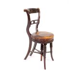 A Regency simulated rosewood music chair, with carved inset cresting, the circular leather seat on