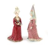 A pair of German porcelain figures of medieval ladies, mid 19th century, wearing elaborately