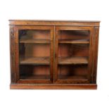 A William IV rosewood book case, with brass line and dot inlay enclosed by a pair of glazed panel