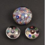 Three 19th Century glass paperweights comprising a Baccaret scramble example, 6.5cm, and two mini