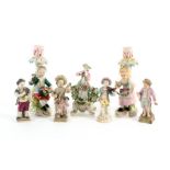Seven various porcelain figures including a pair modelled as candlesticks bearing Derby marks,