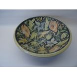 A Butley Pottery ceramic Bowl by Honor Hussey, decorated with pink and blue flowers on a blue