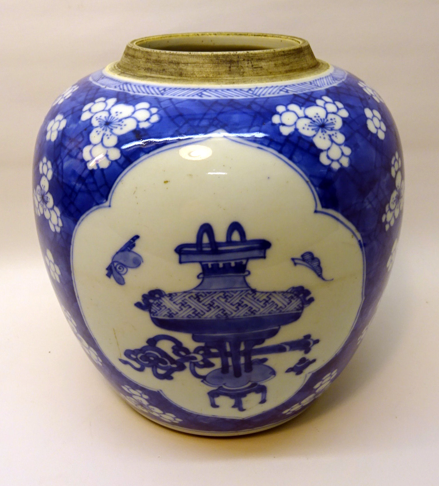 A Chinese Ginger Jar decorated with vases etc in blue and white on a prunus pattern ground. 8 1/