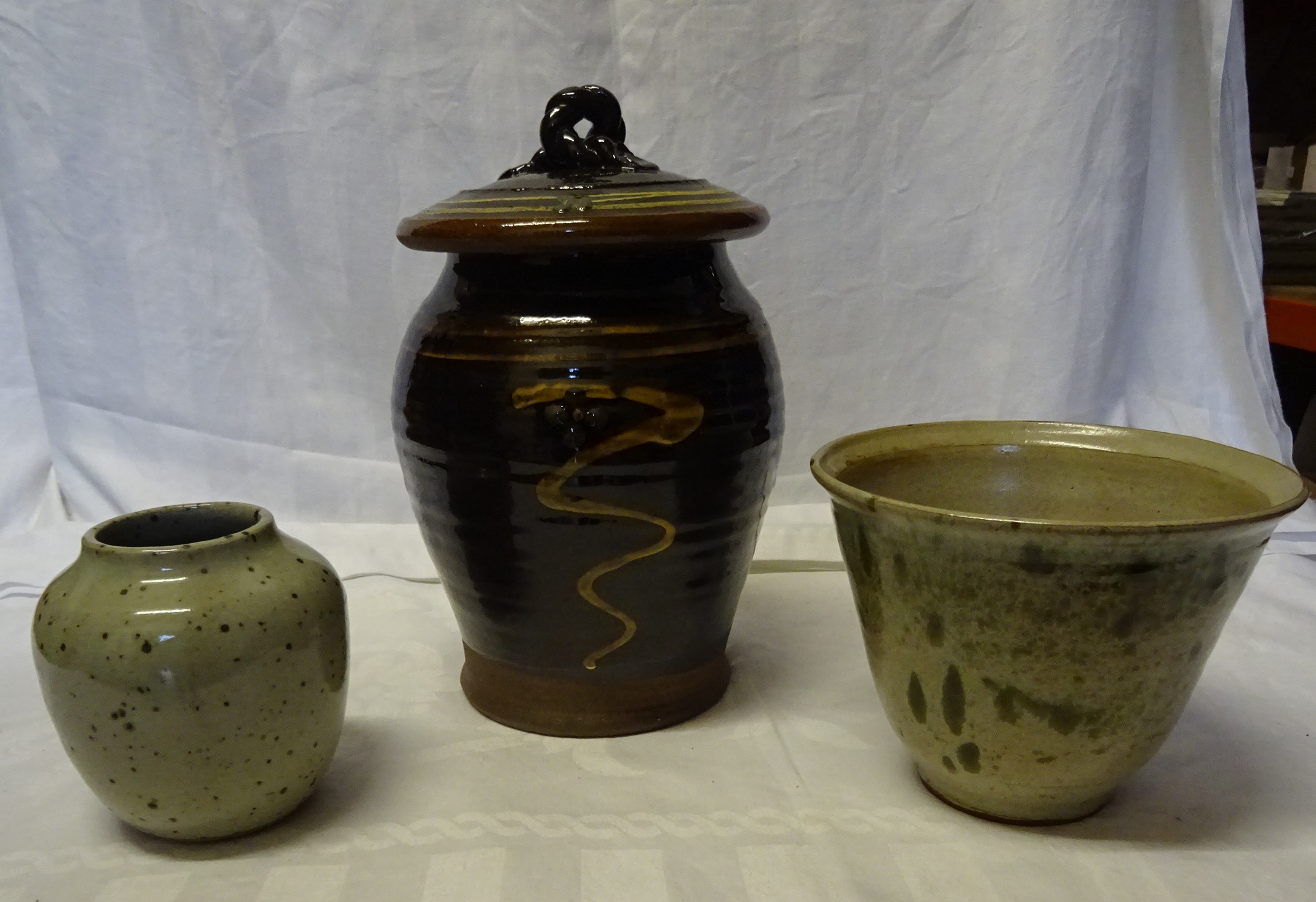 A Slip ware Studio Pottery lidded jar and two studio pottery vases.