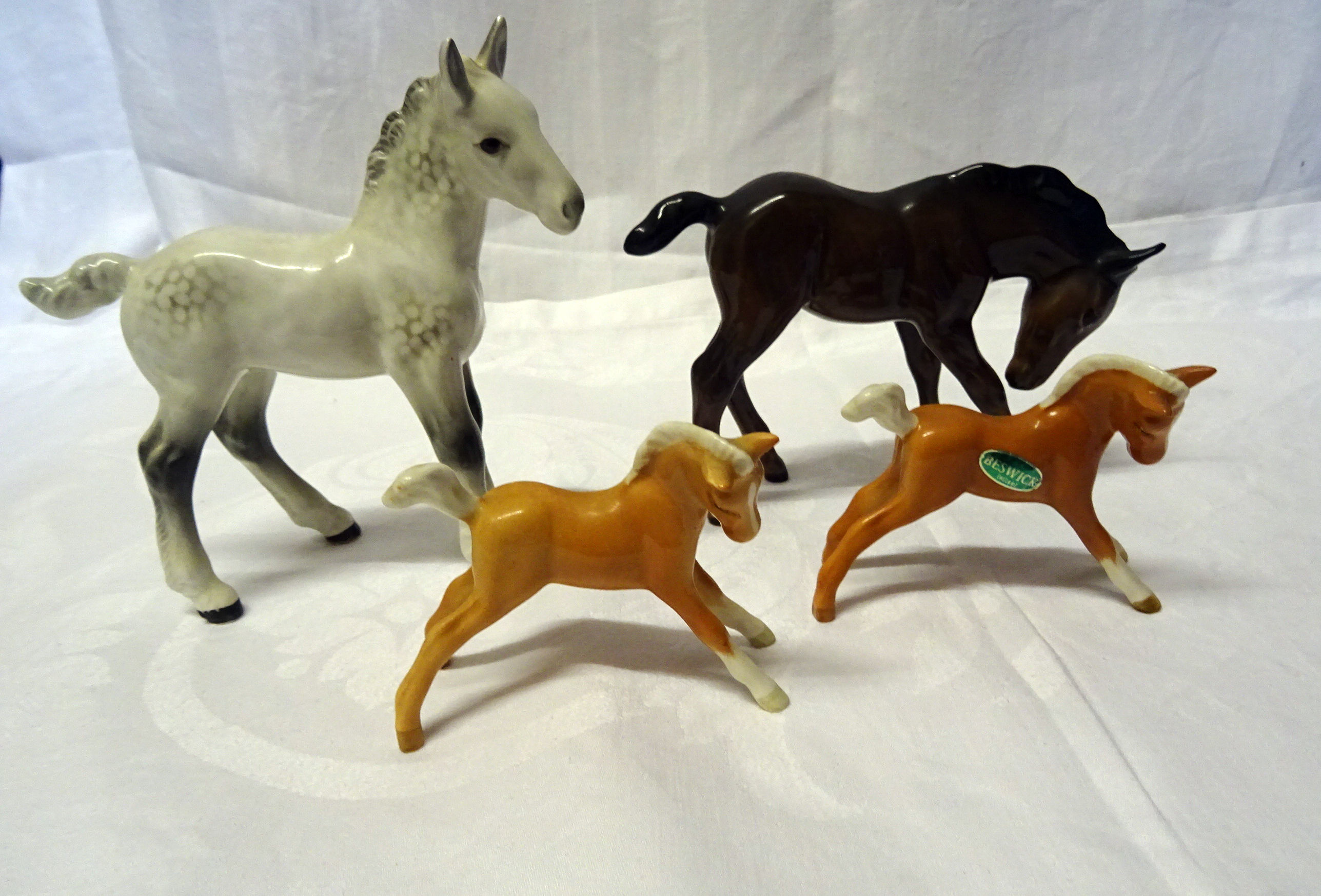 A Beswick Model of large shire foal in grey gloss, No. 951, a large brown foal, No. 947 and two