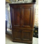 An early 19th Century oak standing two tier corner Cupboard, the upper section with stepped