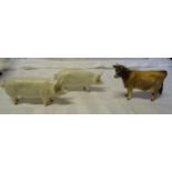 A Beswick Model of a Jersey cow and two Beswick pigs (a/).