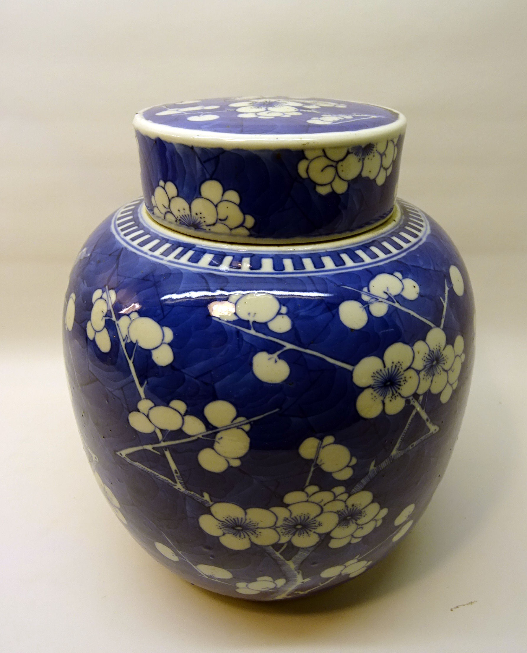 A large Chinese Ginger Jar and cover decorated in blue and white with prunus. 9 1/2" (24cms) high.