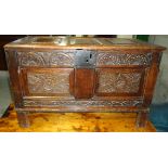 A small early 18th Century oak Coffer with hinged triple panel lid, the double panel front carved