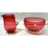 A Cranberry Glass Bowl on lappet feet. 5" (13cms) diameter and a cranberry glass jug.